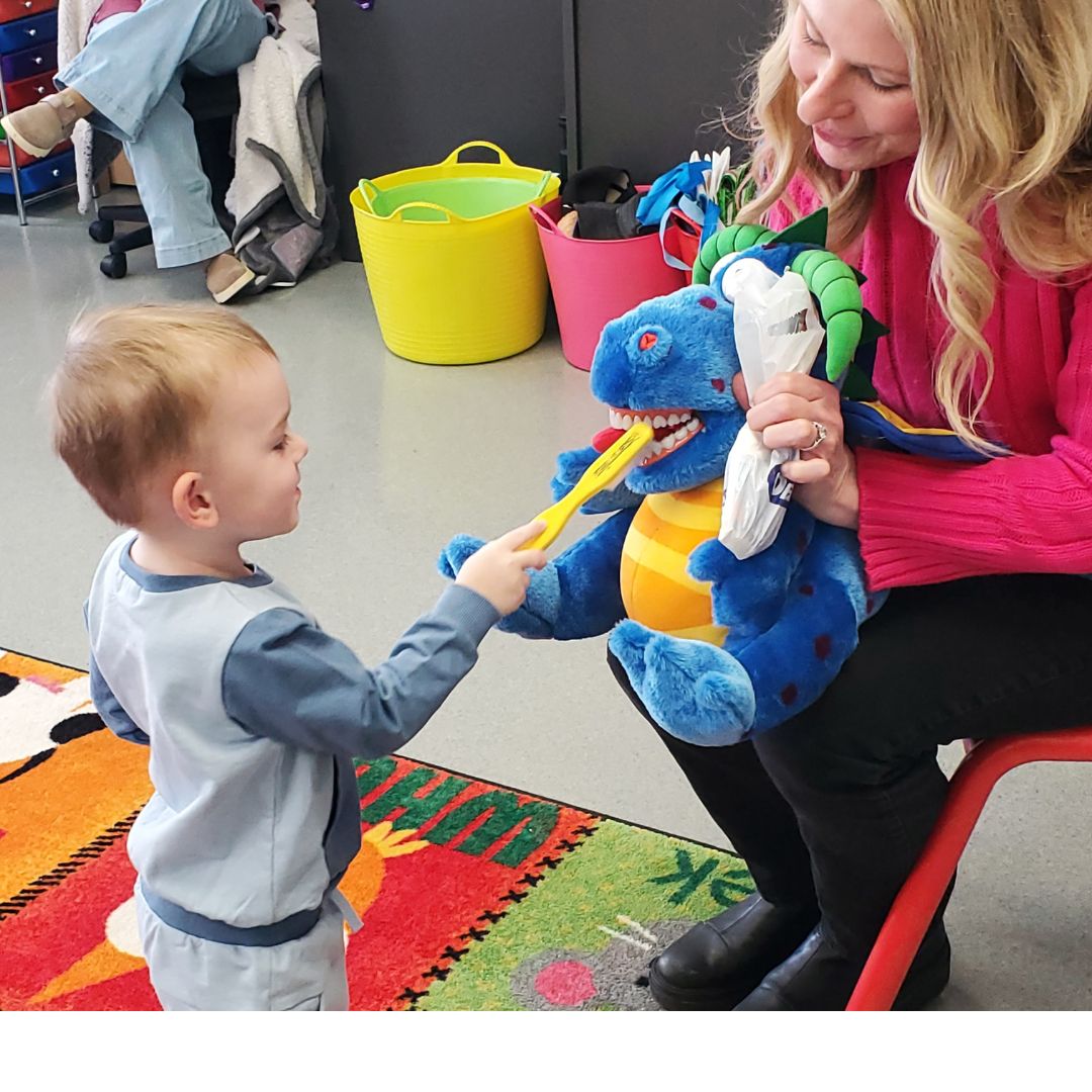 Learning how to brush your teeth with stuffed dragon