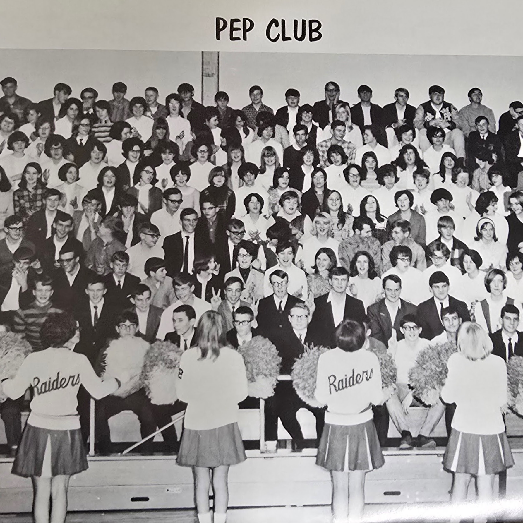 Black and white picture from old Shiloh yearbook of Raiders cheerleaders facing bleachers of students entitled "Pep Club"