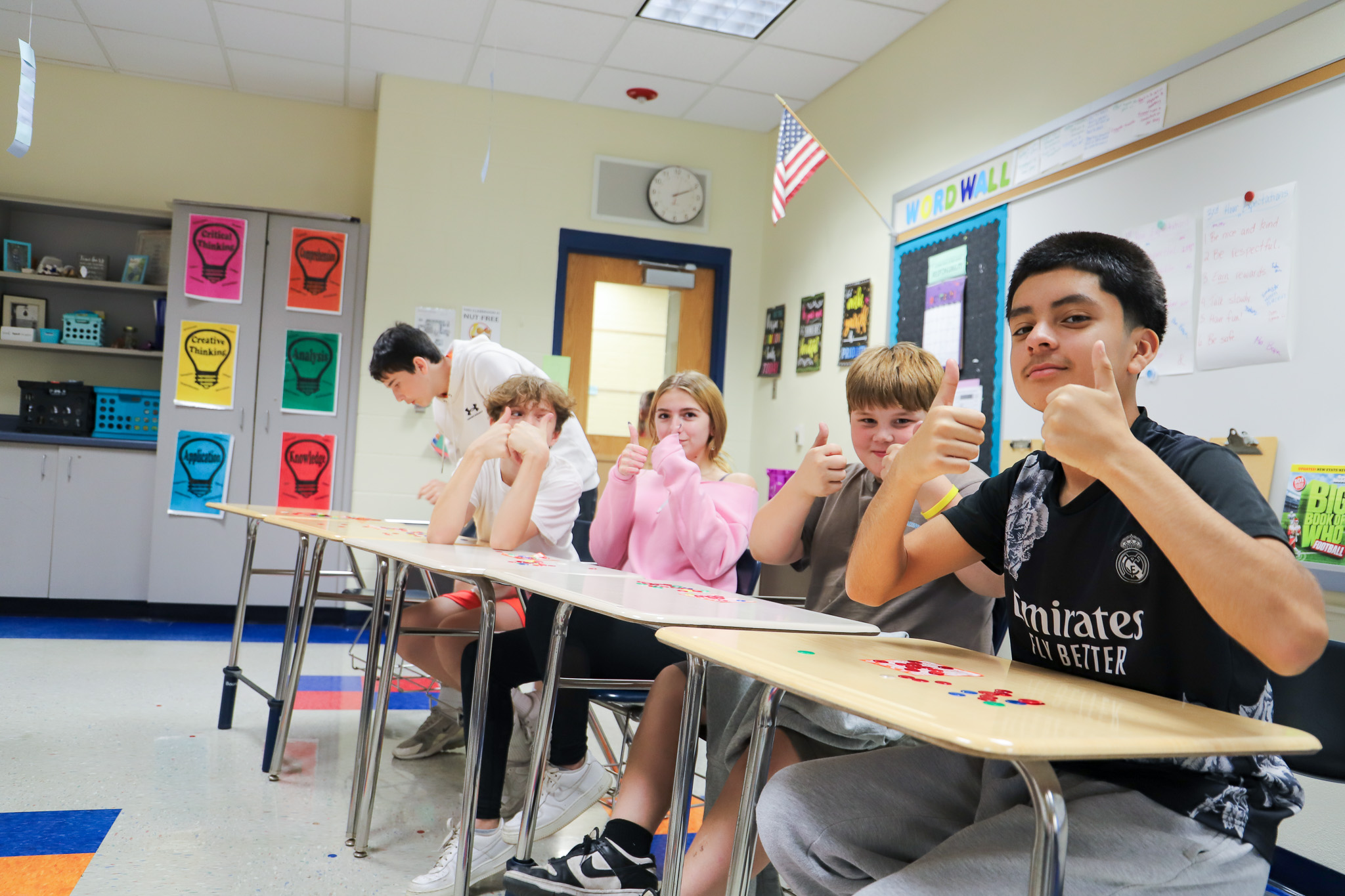 image of students at desks giving thumbs up