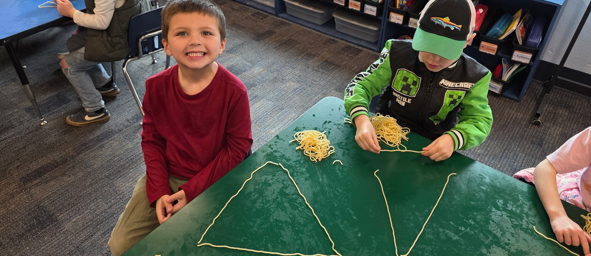 students making geometric shapes with noodles