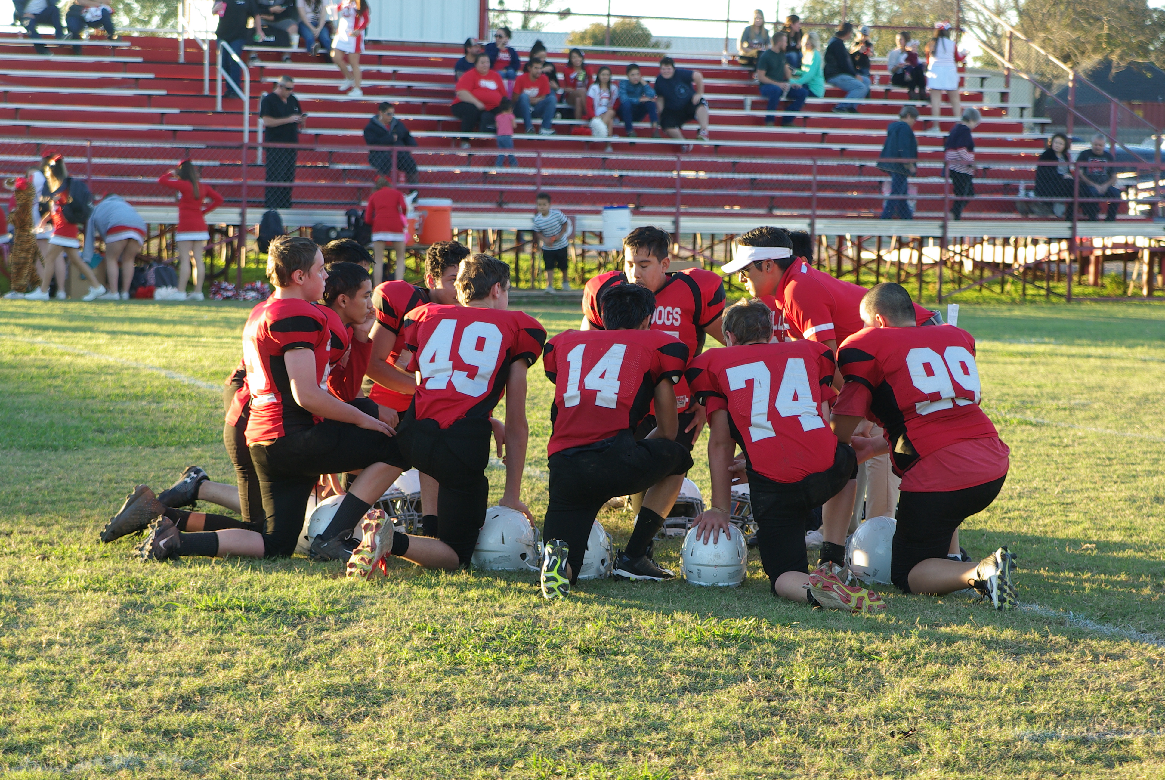 Football team kneeling for game plan