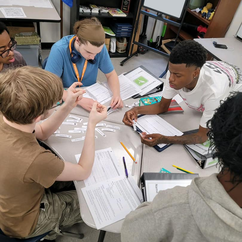 Students working at a table in a group