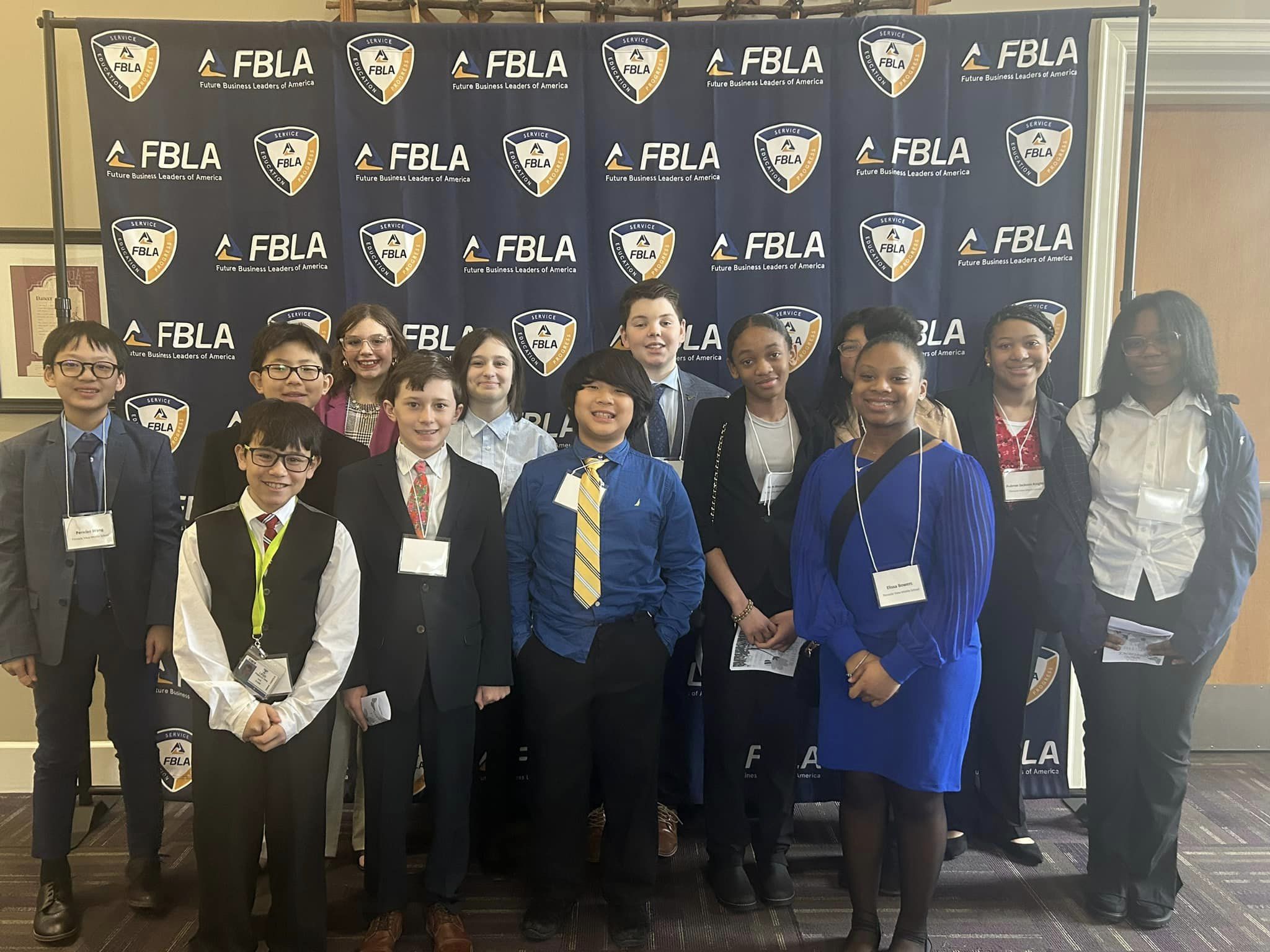 FBLA Students posing in front of an FBLA background