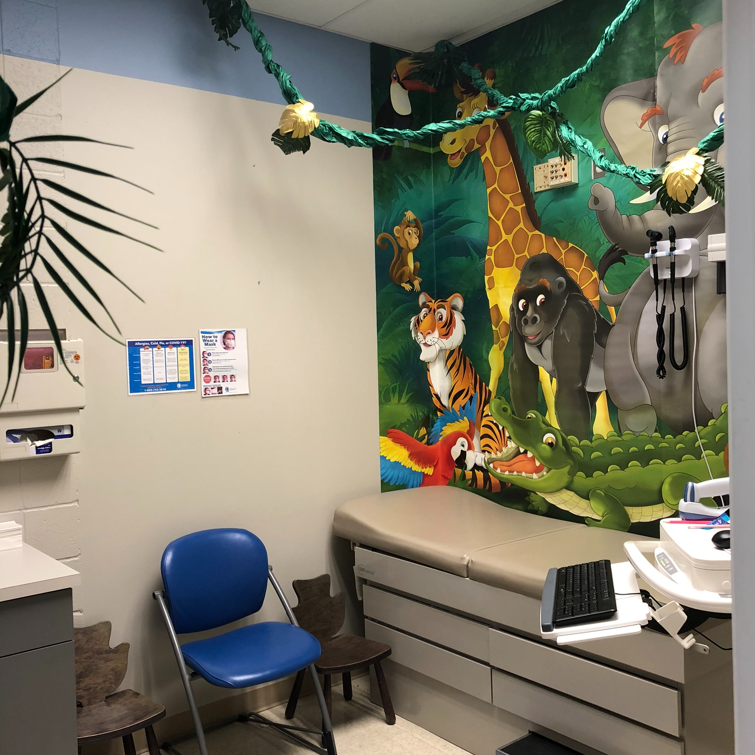 Exam room with jungle-themed wall covering. 