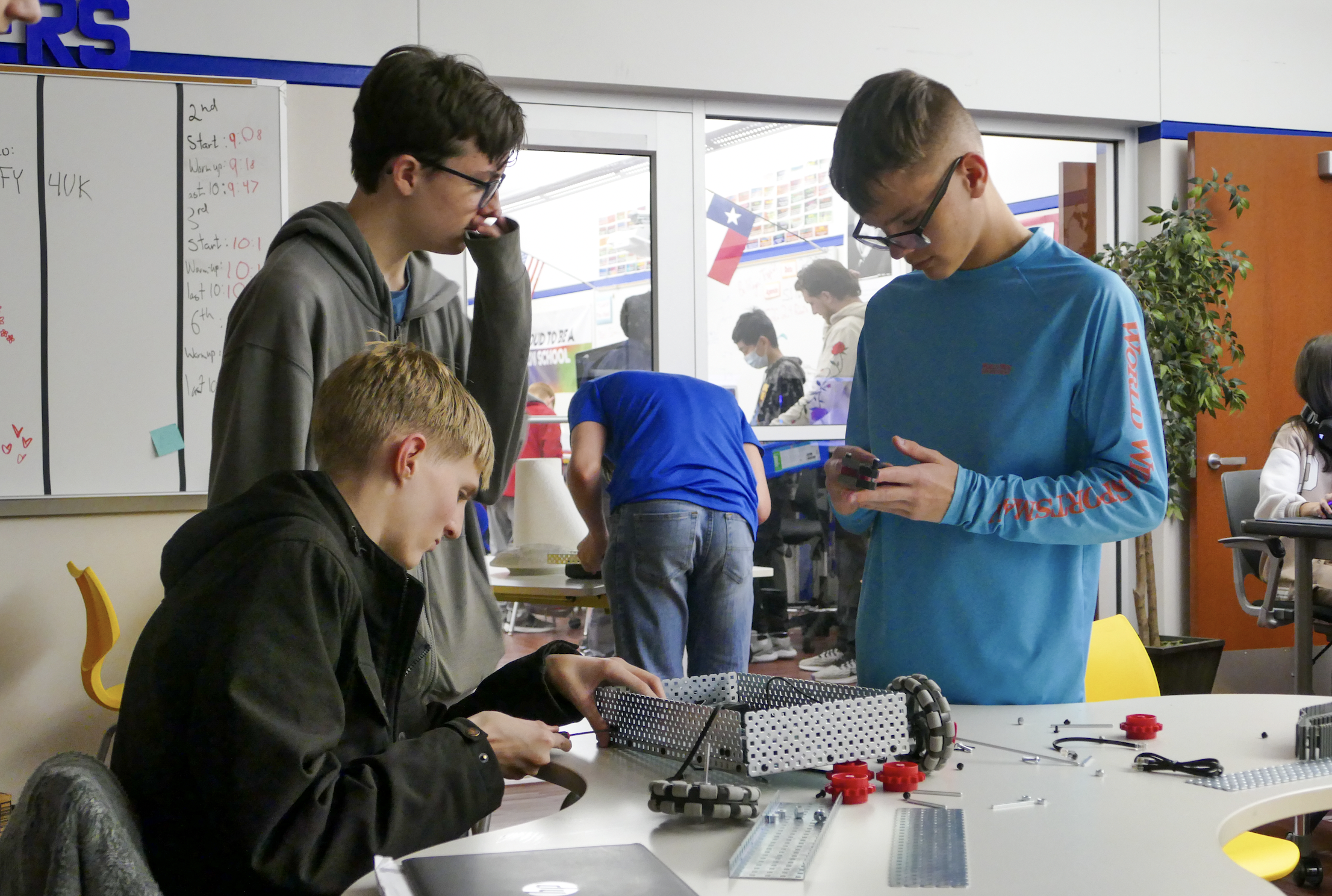 A group of students in a STEM class work on a project that looks to be a form of robotics.