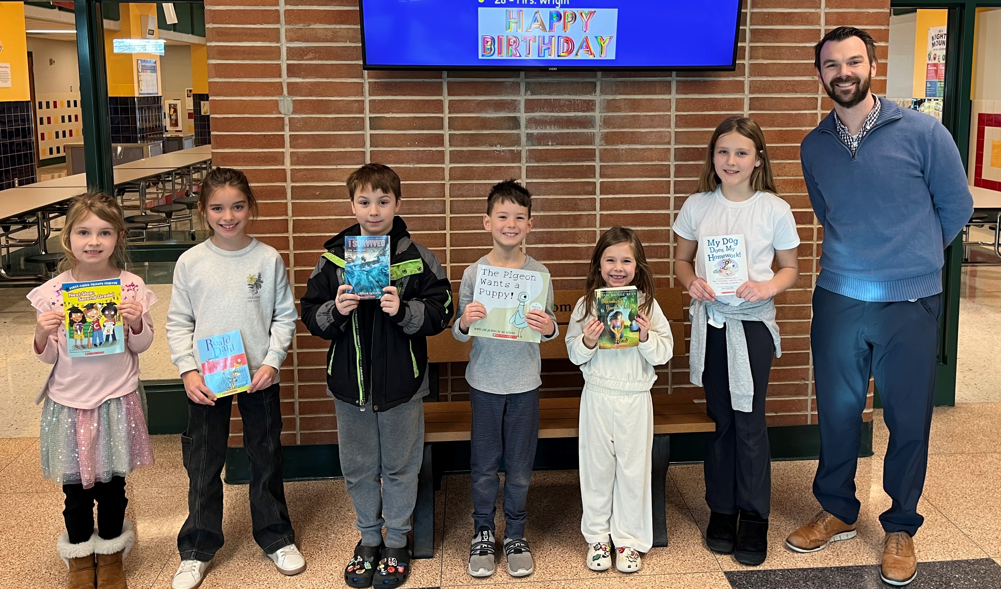 Students hold books they won