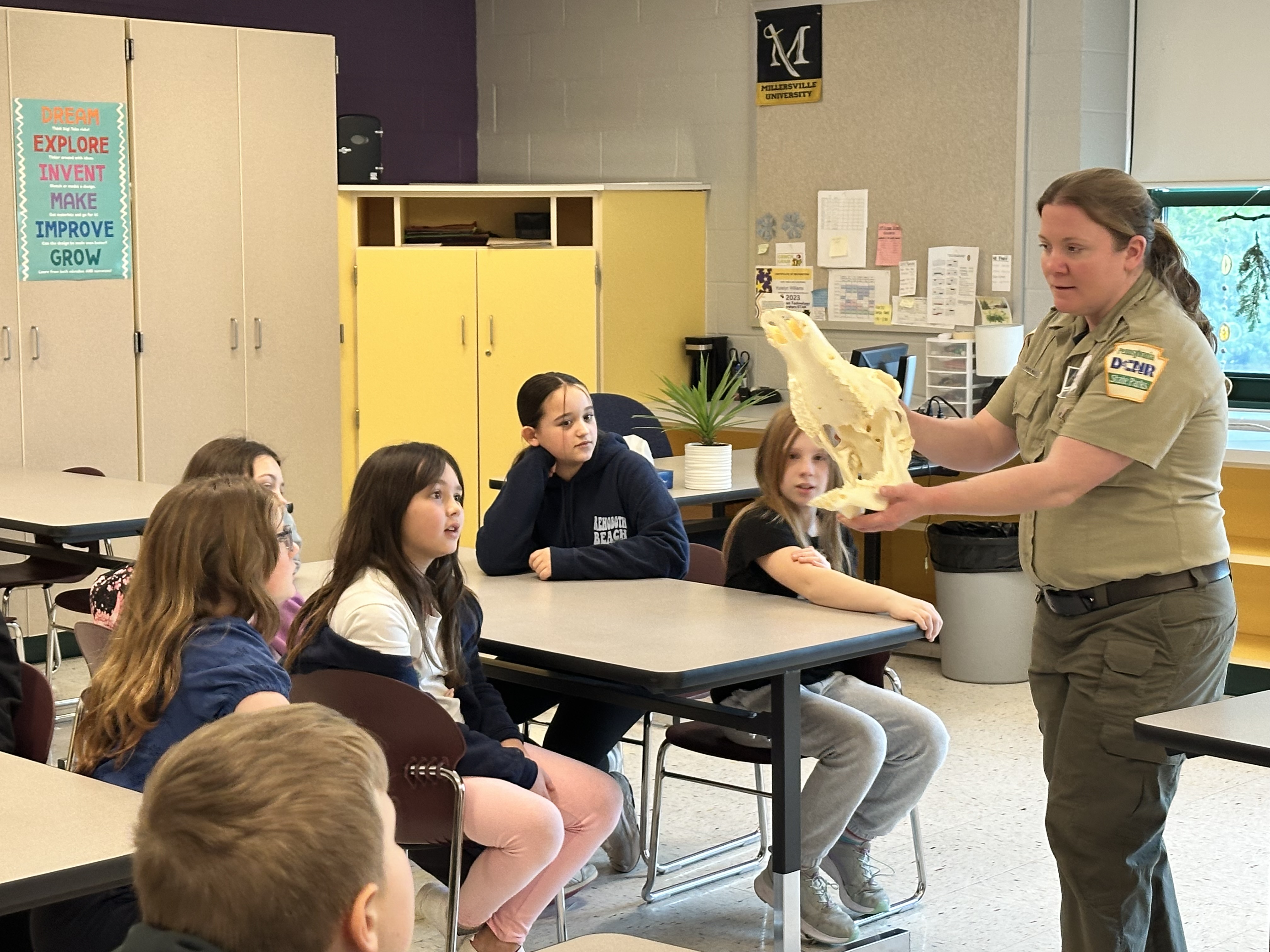 Conservation Officer shows an animal skull to students