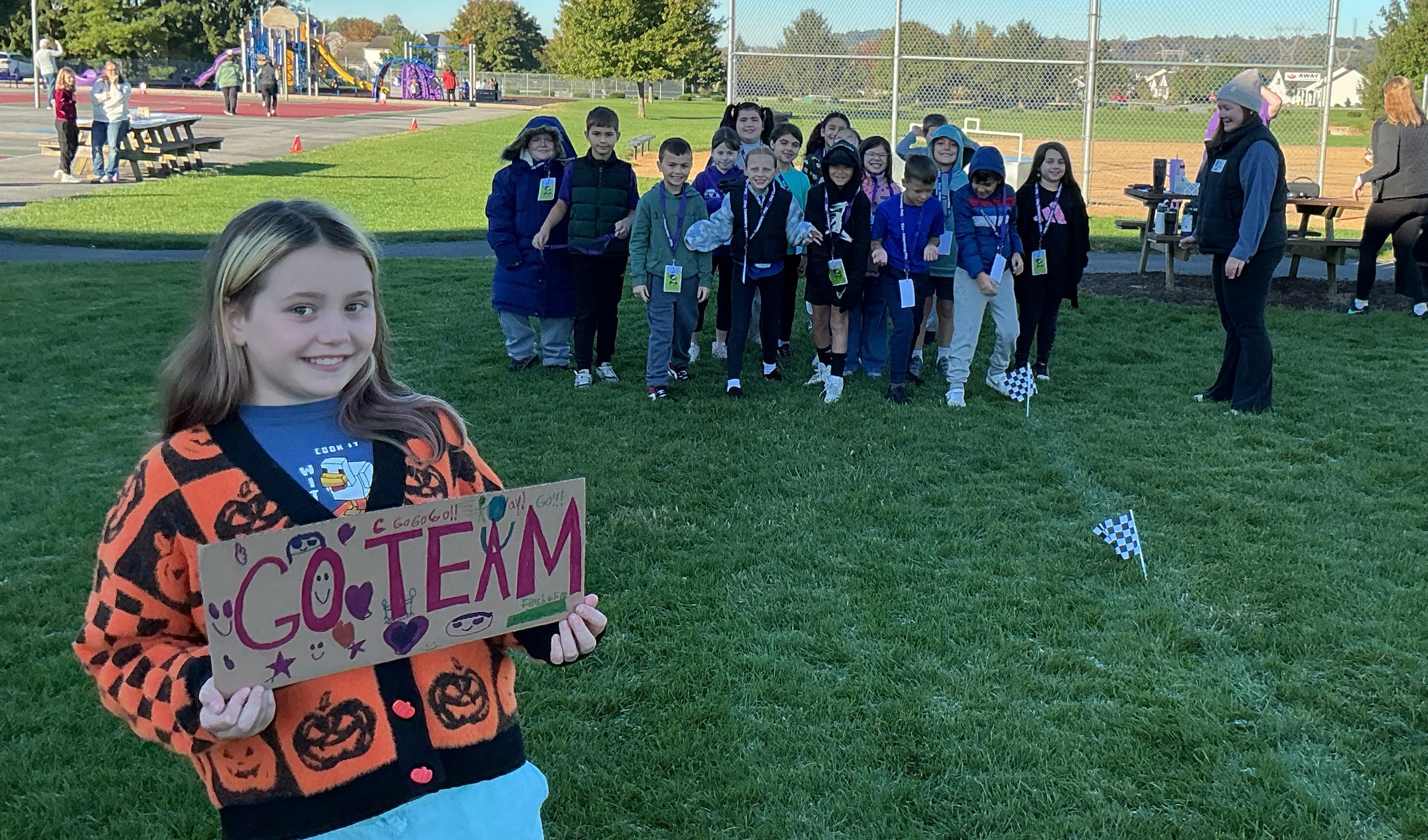 Student holds sign encouraging her team for Fun Run