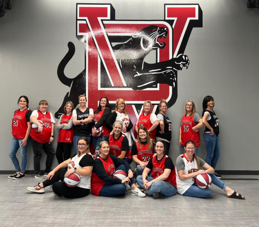 staff pose for photo with basketballs 