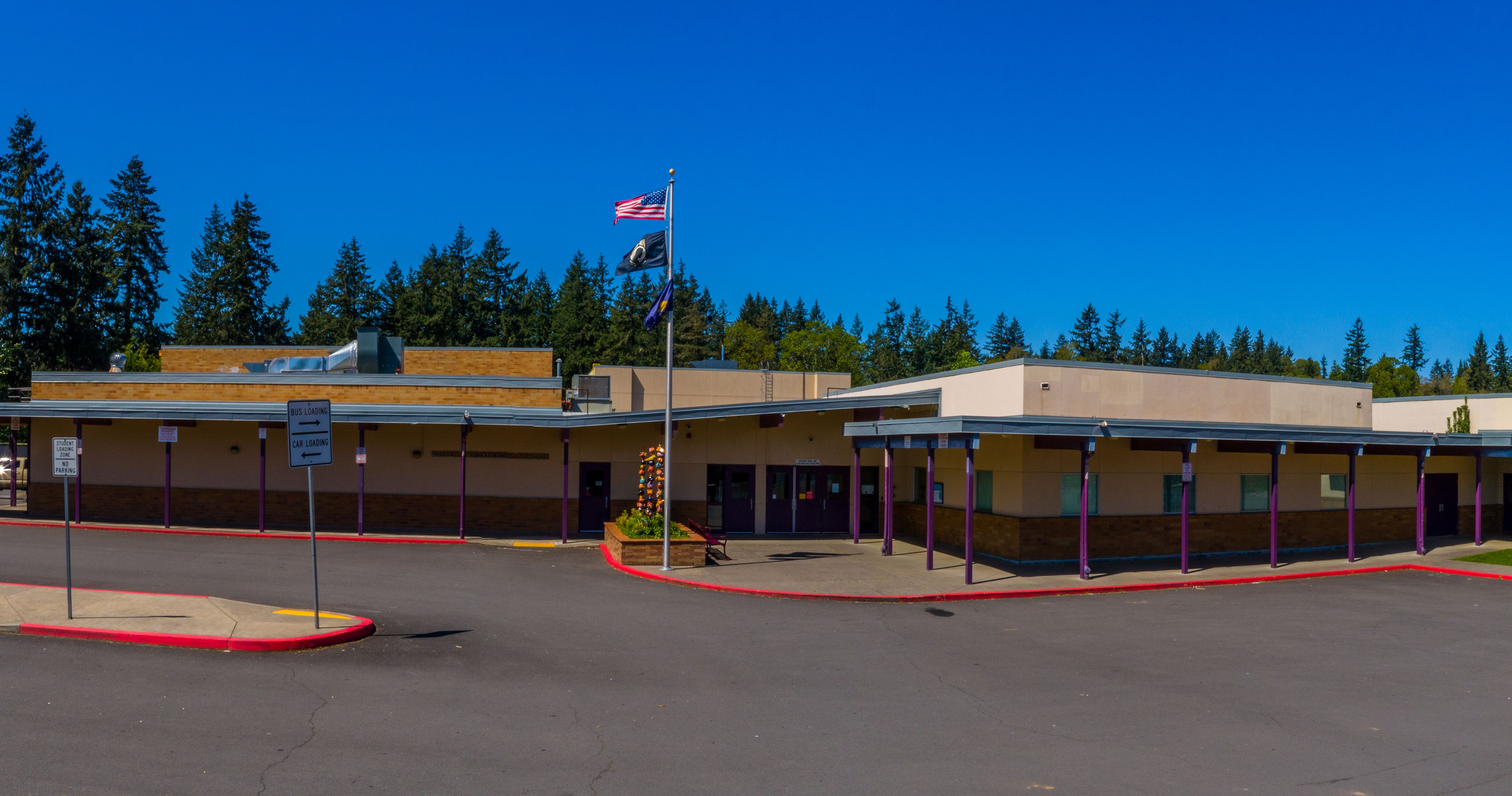 panoramic of wlk middle school front building with american flag waving and horizon