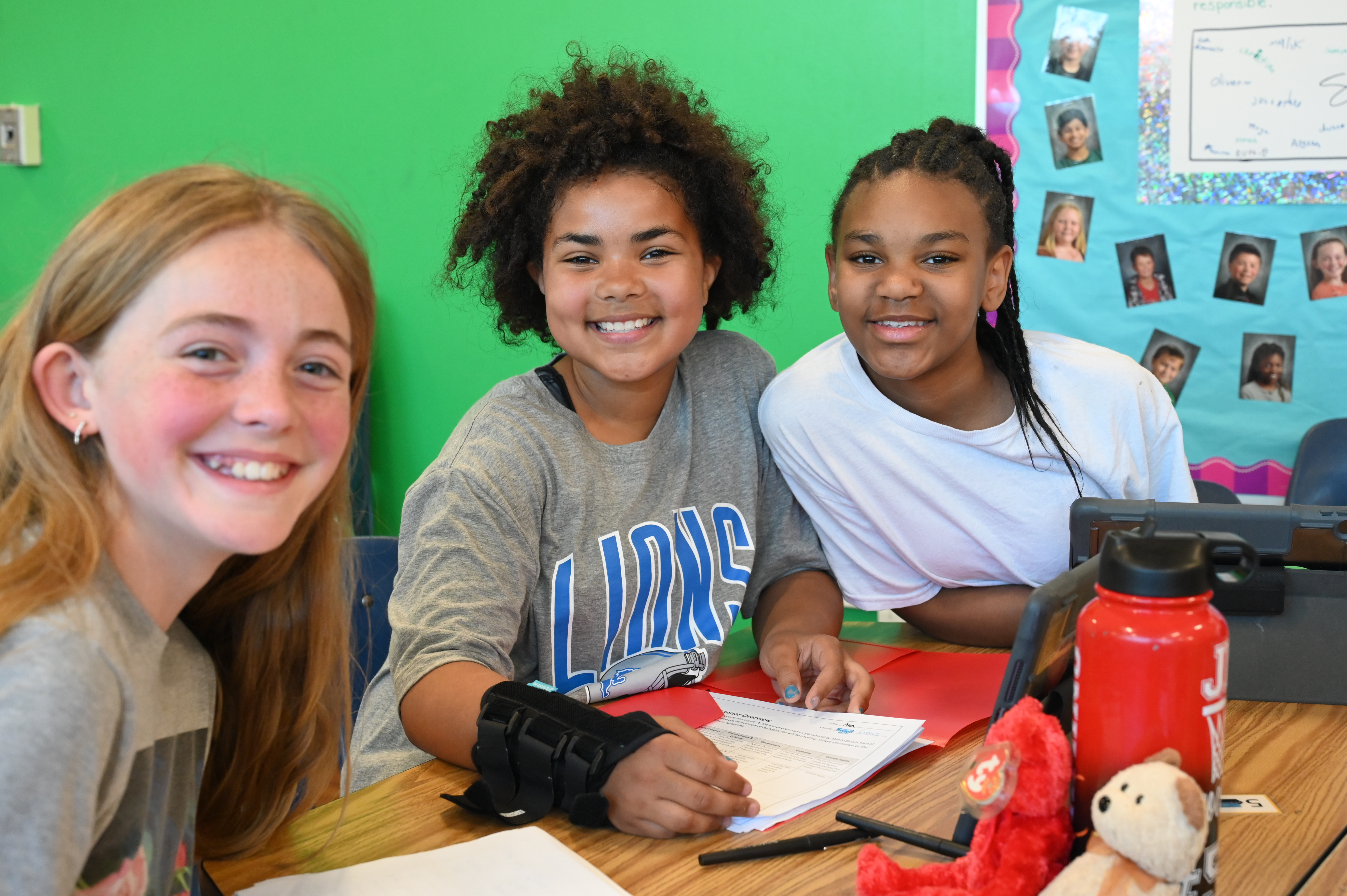 Lincoln uppers students working on classwork smiling at the camera