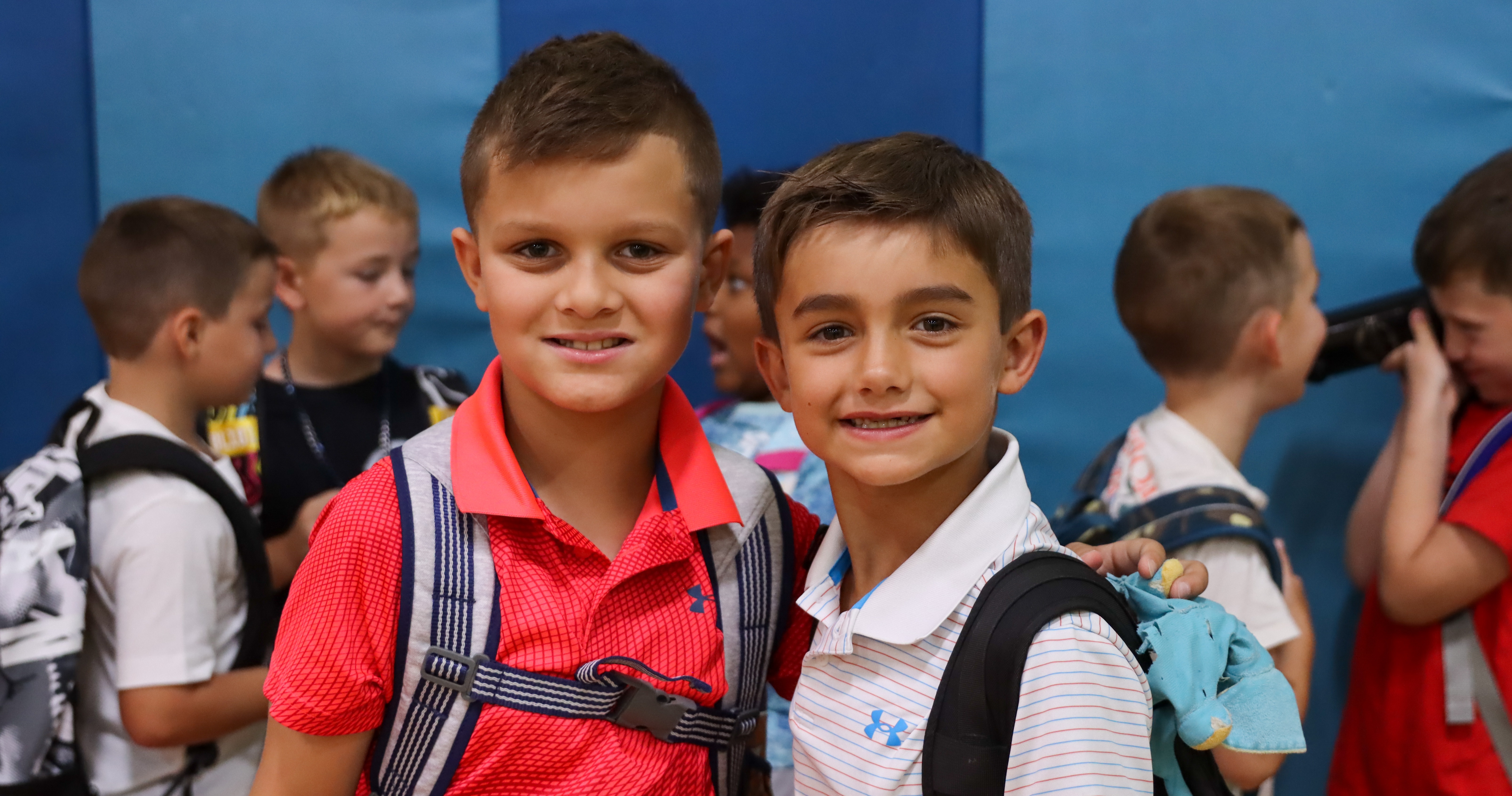 Two students pose and smile together on the first day of school.