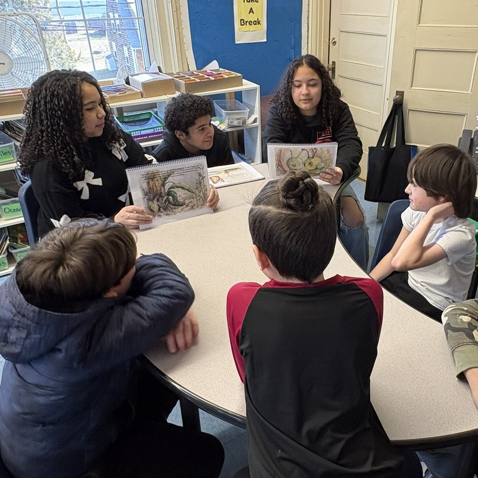 High school EL students reading to younger kids at Hedge Elementary.