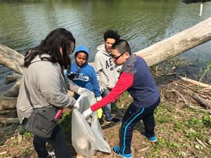 Global Scholars students engage in a clean-up by the water.   