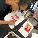 Student drawing a picture of Fritos corn chips bag