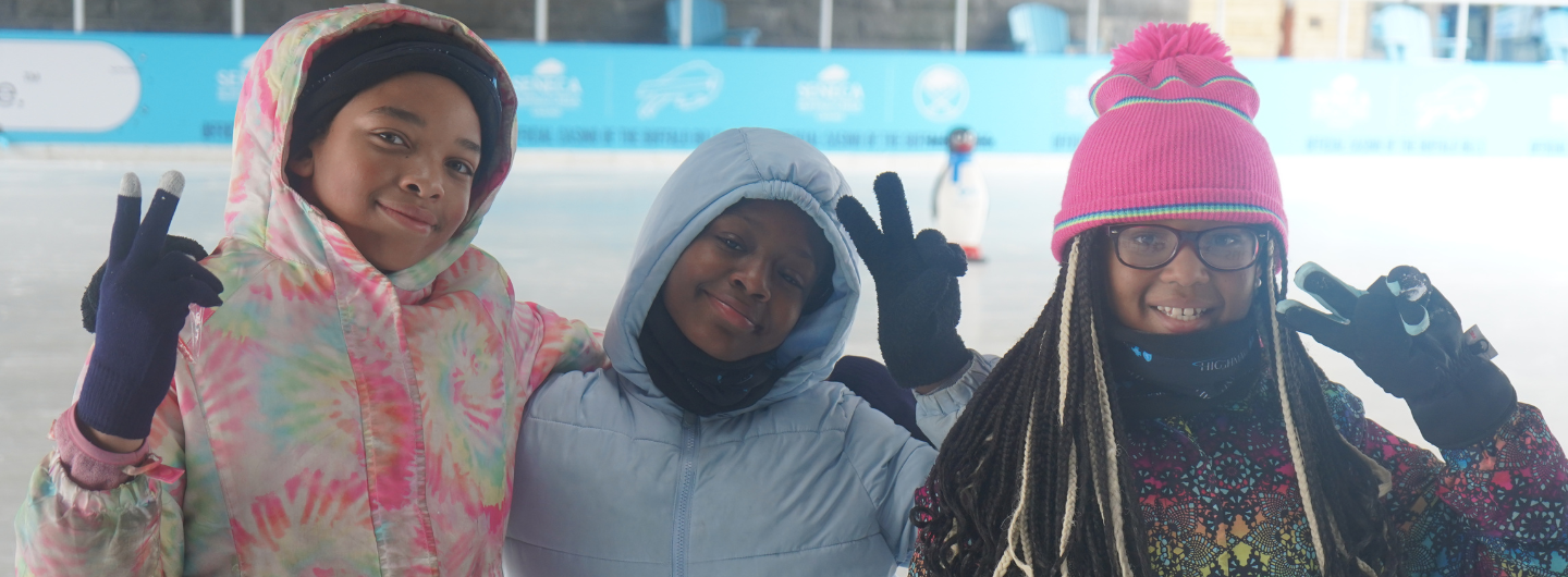 3 Girls posing for picture at ice rink