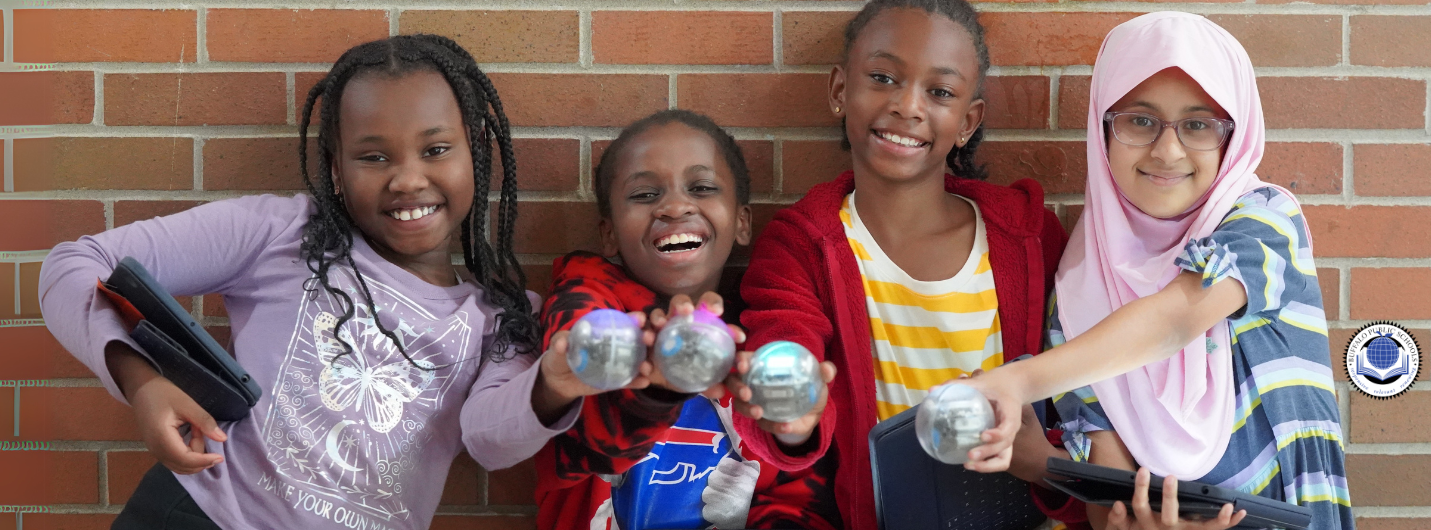 Students smiling and holding a spherical robot.