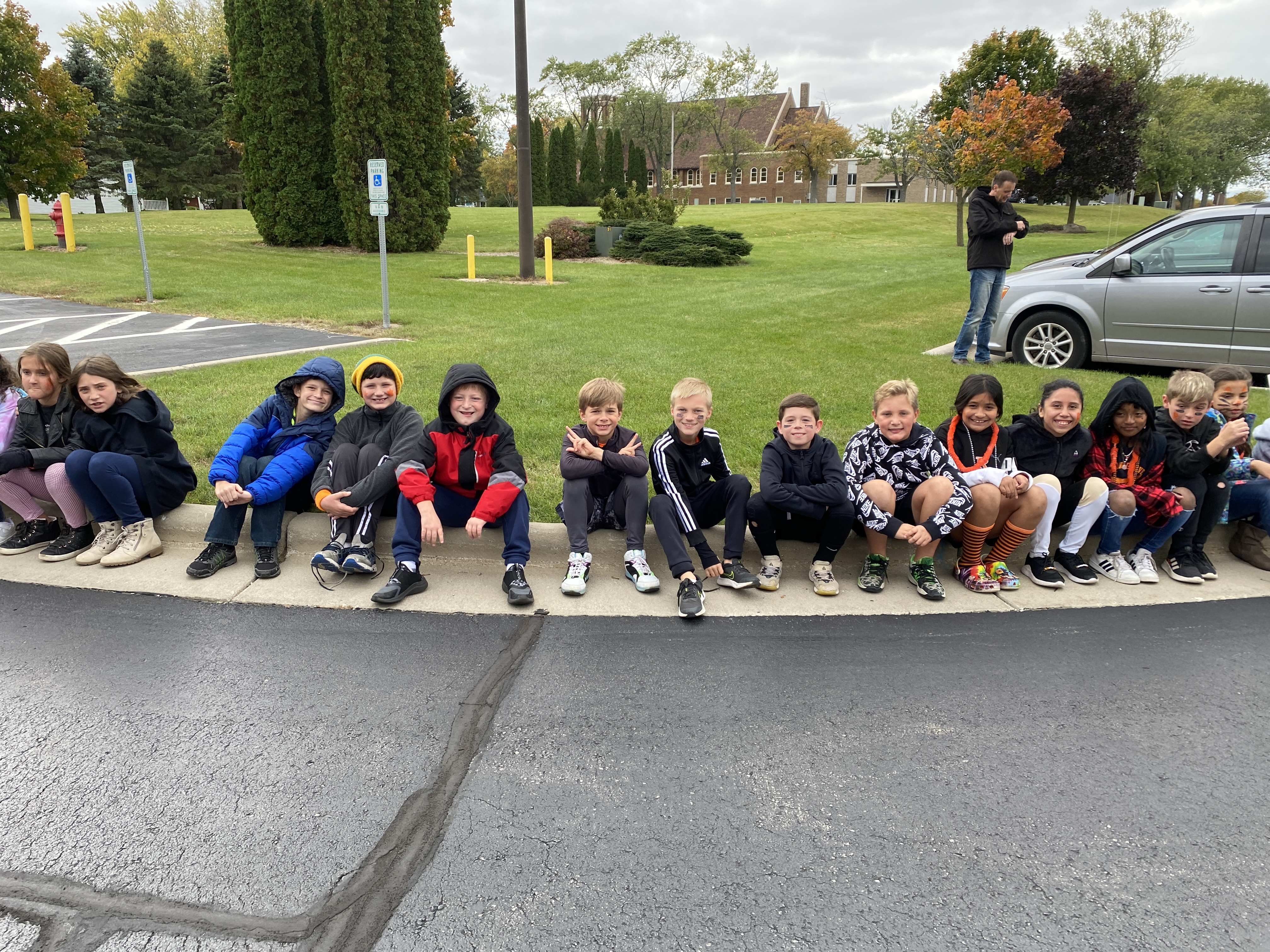 Students waiting on the curb for the Homecoming parade 