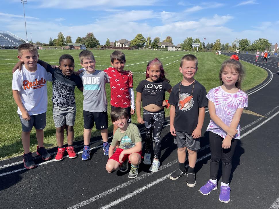 Students smiling while on the track