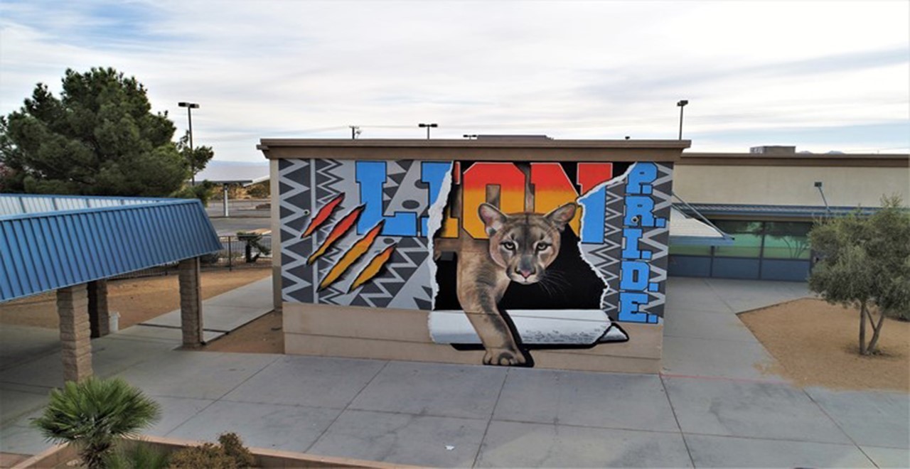 an intricately detailed mural of a lioness stepping through a torn piece of text that reads "Lion PRIDE"