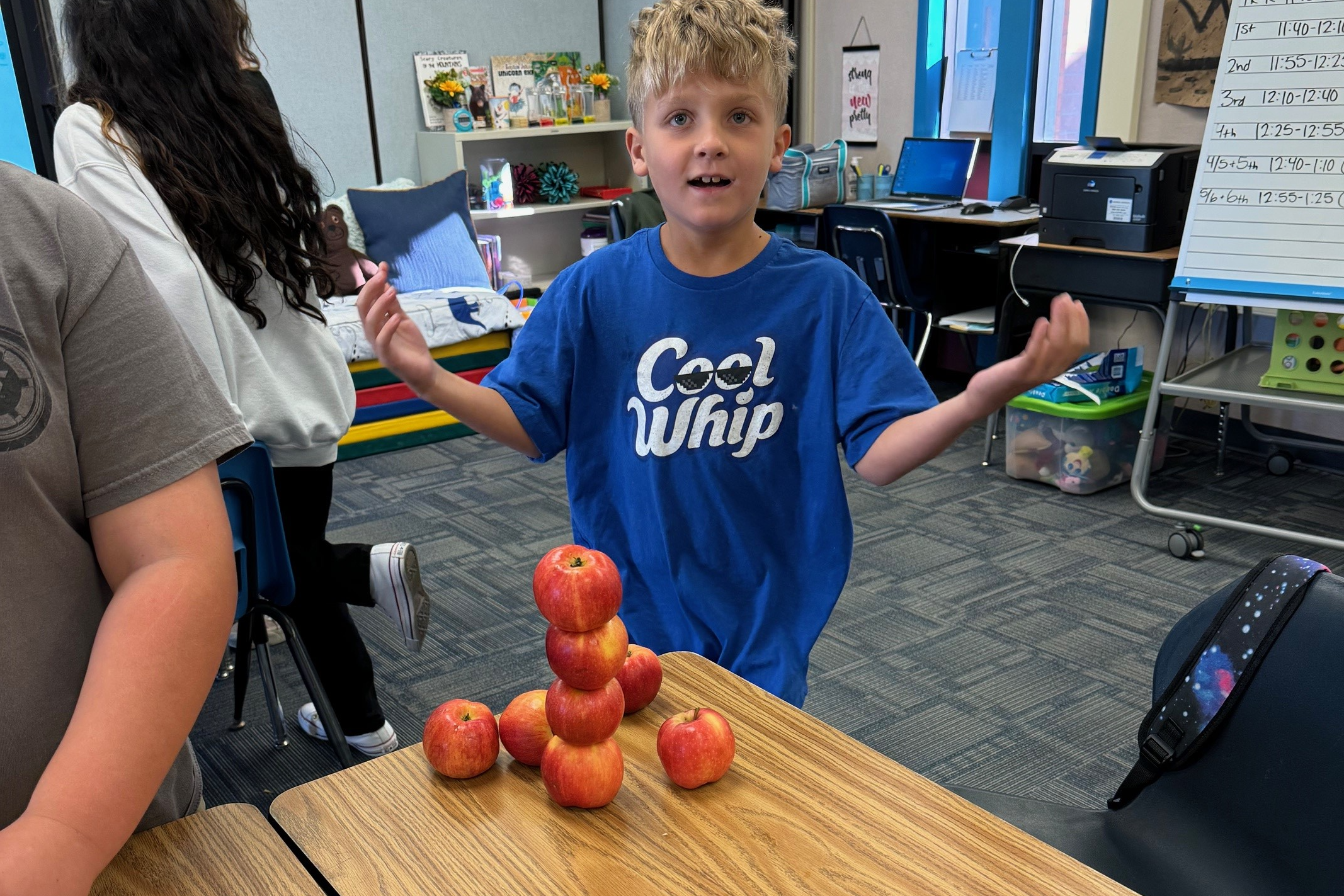 student stacking apples