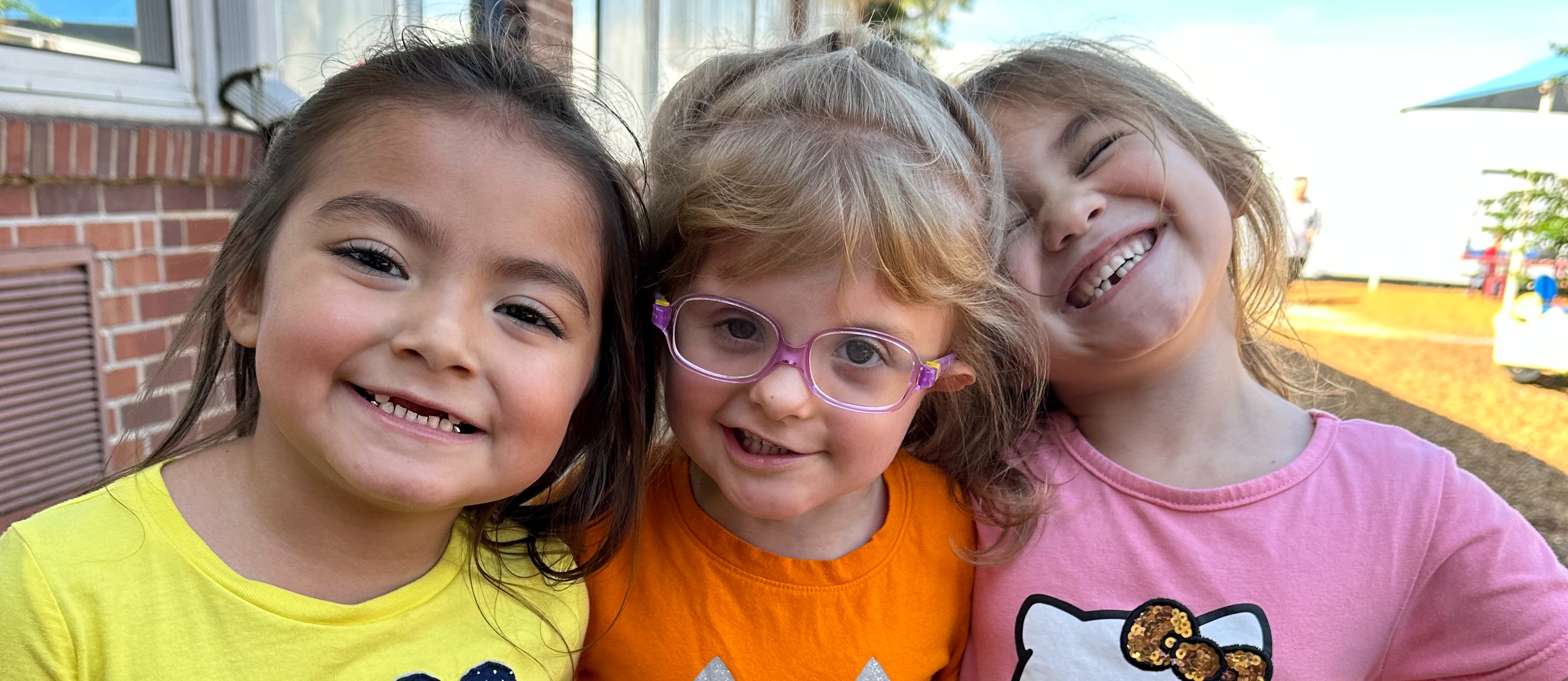 Three pre-k students on playground.