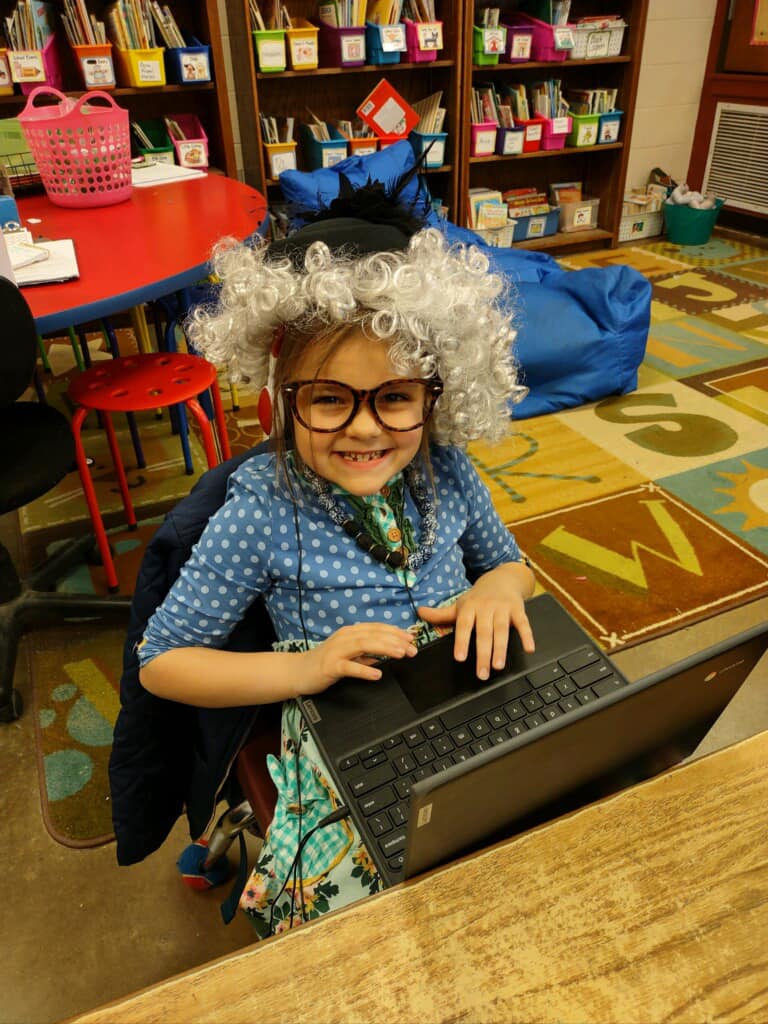Elementary student smiling wearing gray curly wig