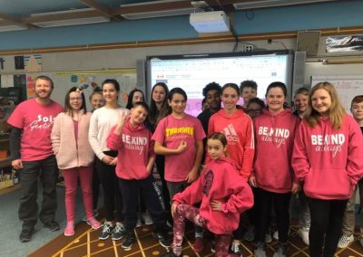 students and teachers in a classroom all wearing pink