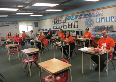 teachers sitting at students desks