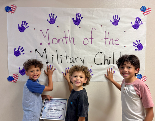 Picture of students in front of a month of the military child sign