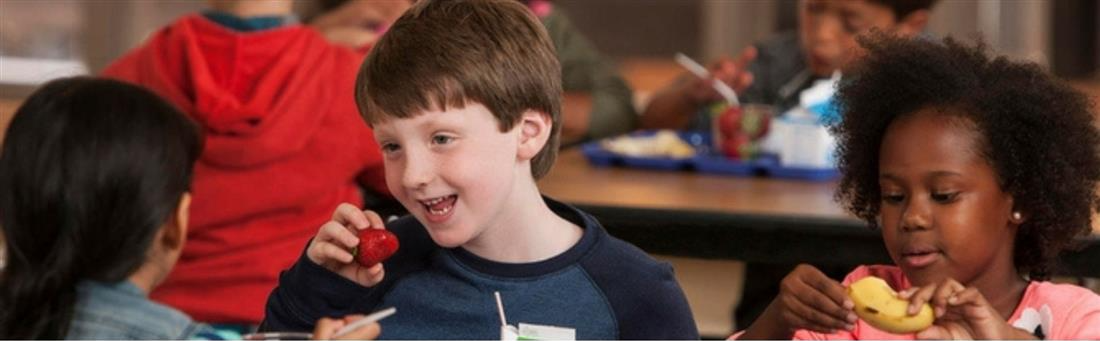 a boy and girl eating fruit