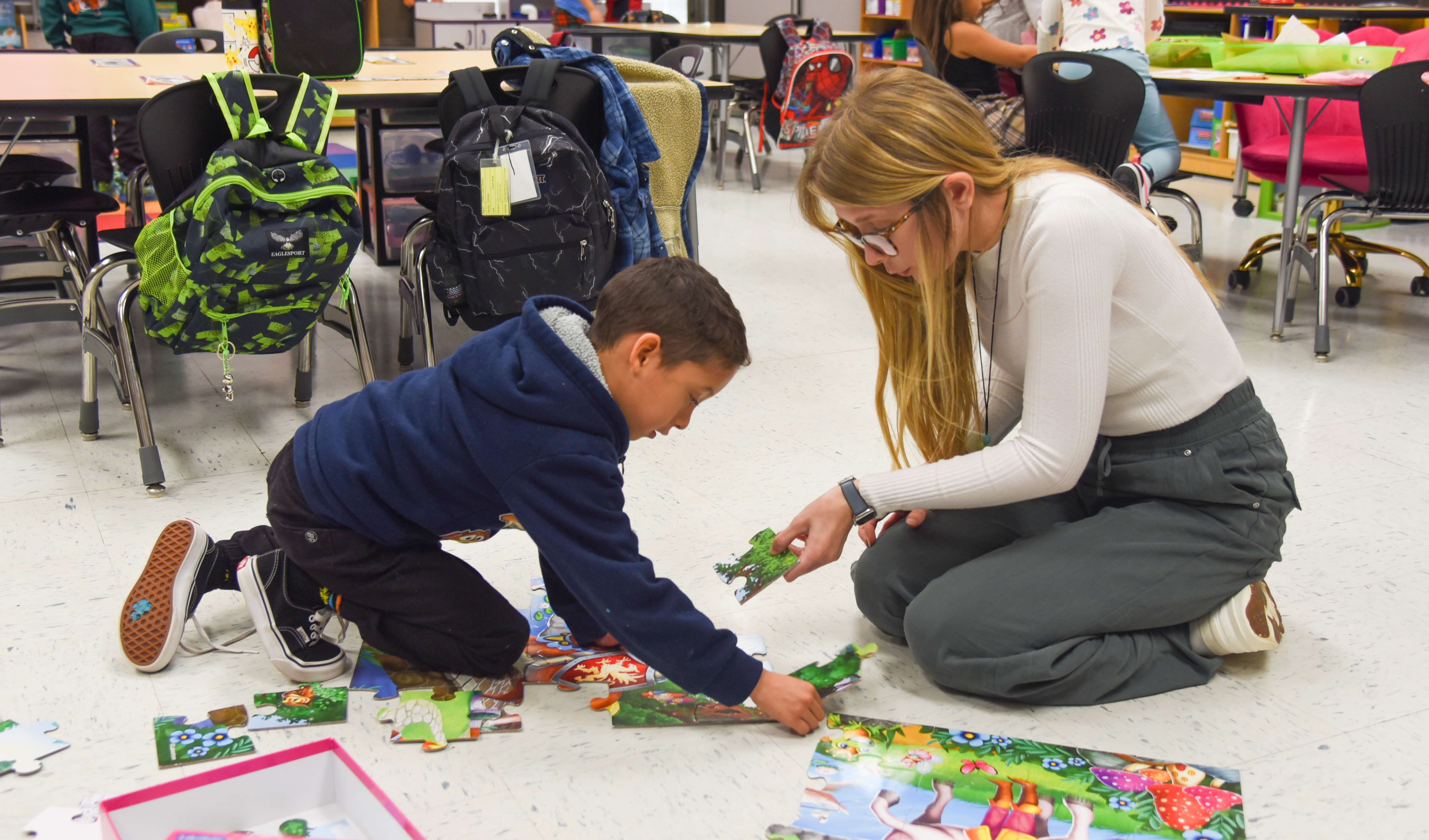 student and teacher putting together a puzzle