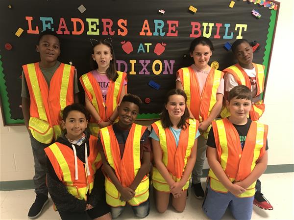 hallway patrol team smiling with orange vest 