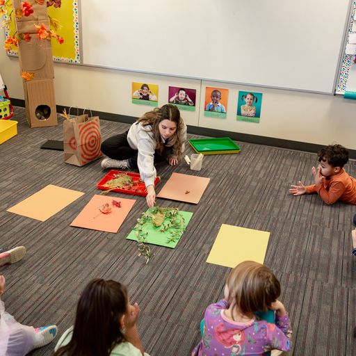 Preschool teacher instructing students on how to match colors and objects on the sheet.