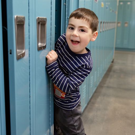 Preschool boy reaching into his locker at Northrop.