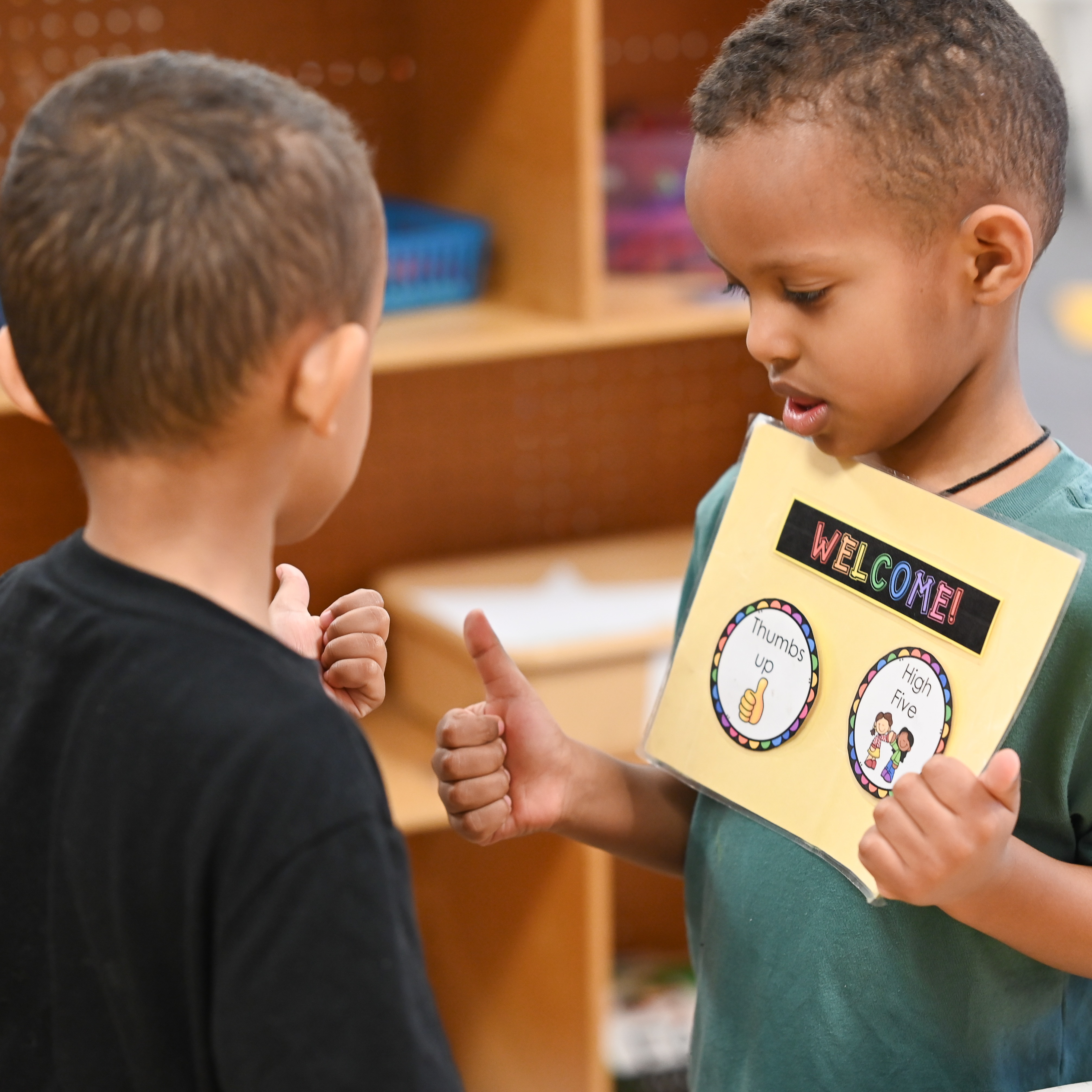 Student welcoming student into class