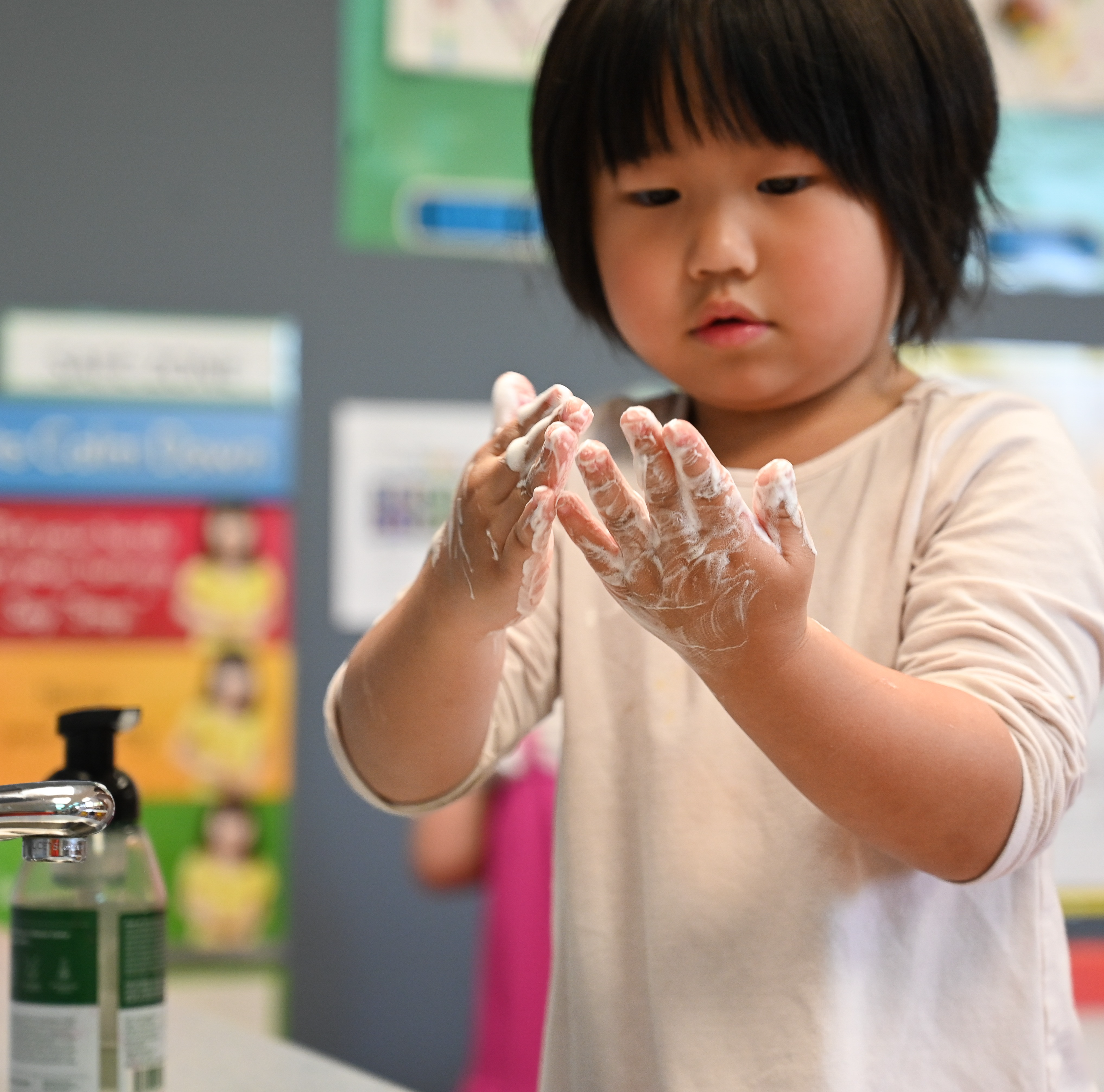 Preschool student washing her hand before snack time.