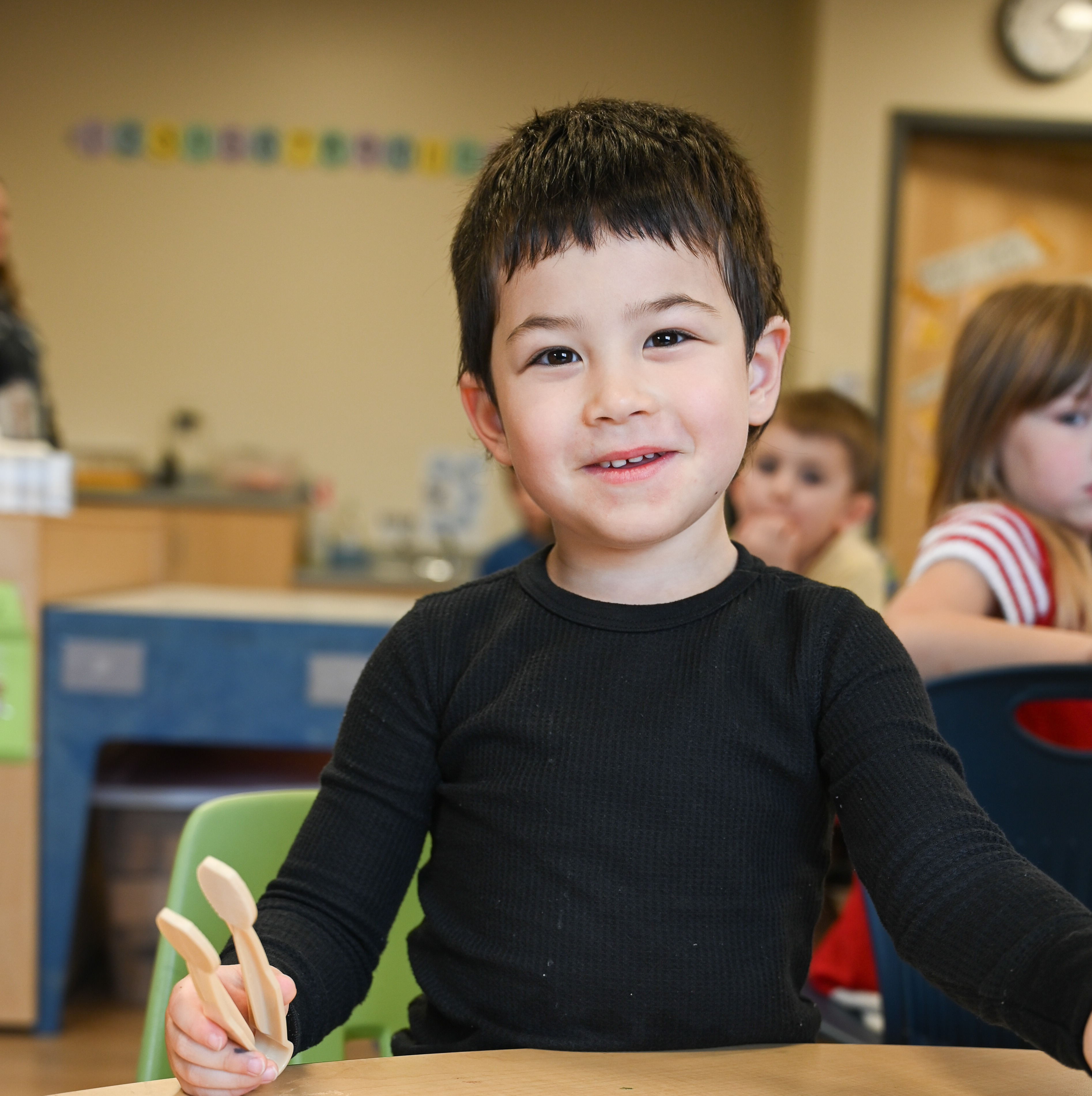 Preschool student eating yogurt at snack time