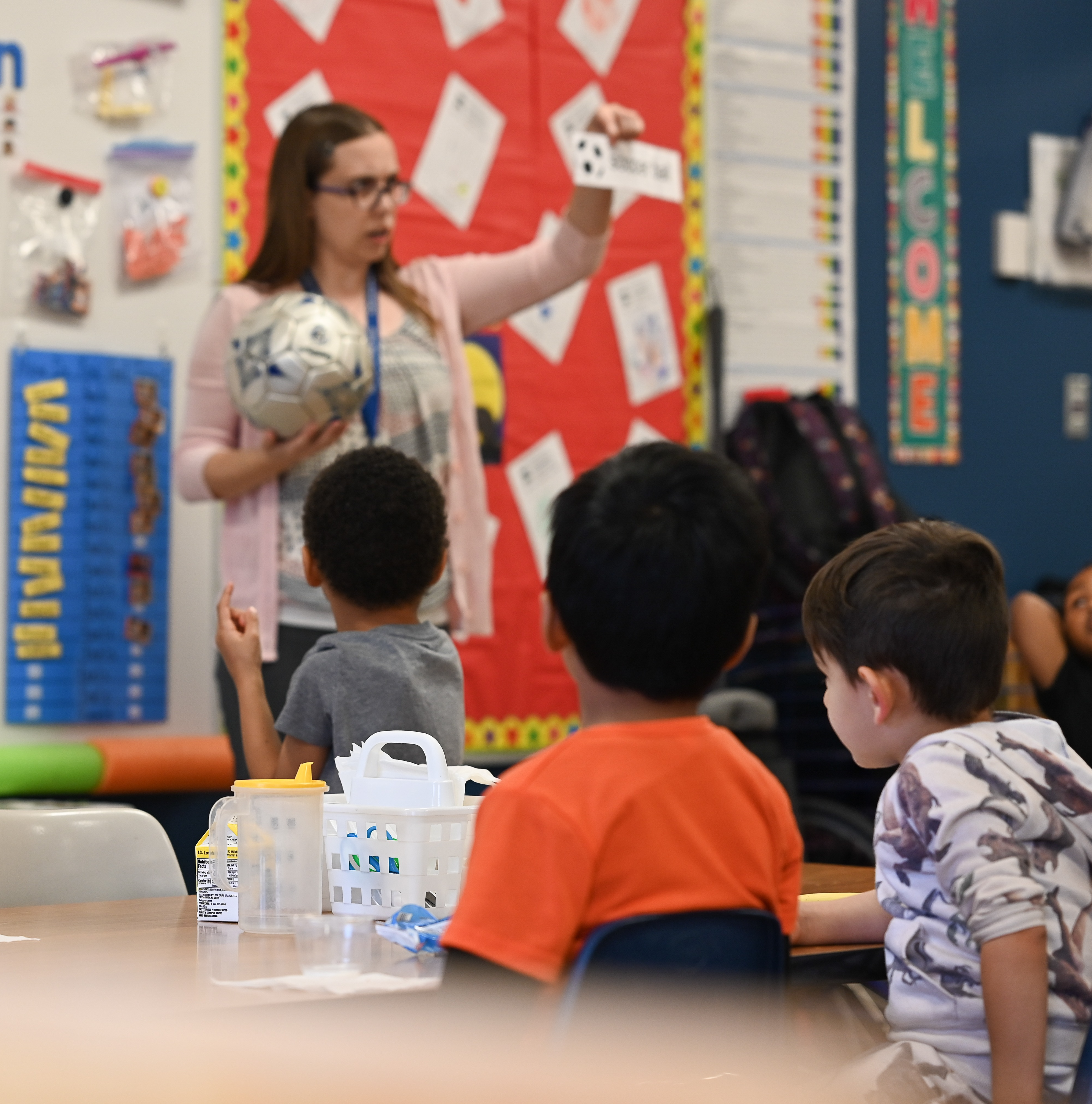 Preschool Teacher working one-on-one with two preschool students at a table