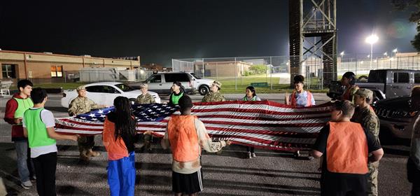 students folding a flag