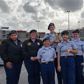 six JROTC students in uniform holding a trophy