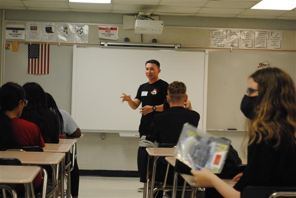 man presents to students in a classroom