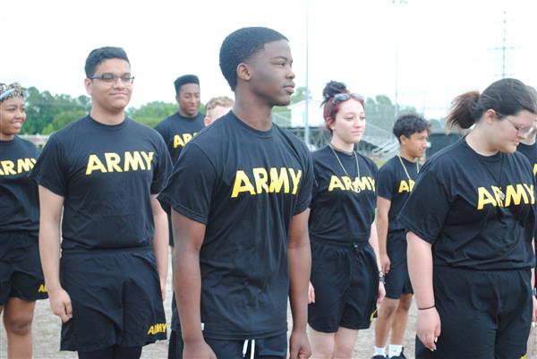 students outdoors in rows wearing matching Army shirts