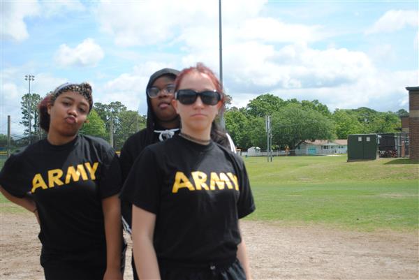 three students outdoors wearing matching Army shirts