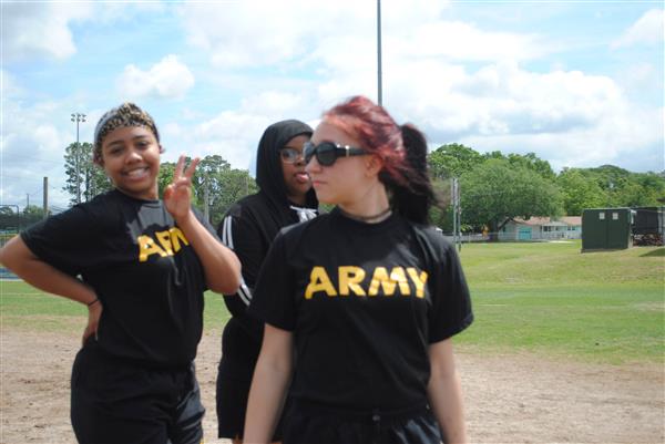 three students outdoors wearing matching Army shirts