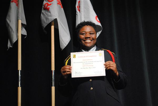 student on stage holding a certificate