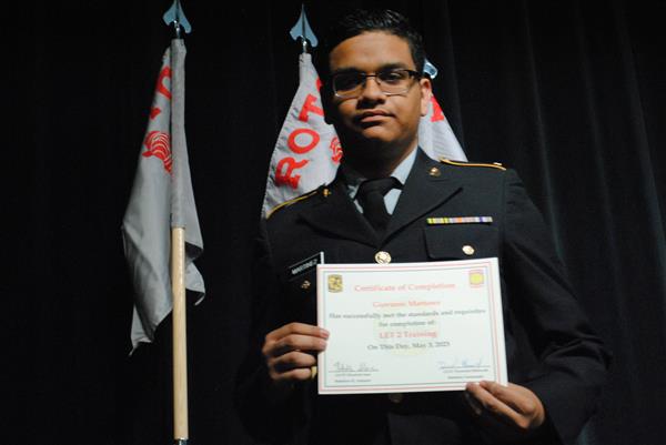 student on stage holding a certificate