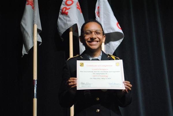 student on stage holding a certificate