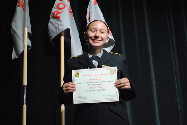 student on stage holding a certificate