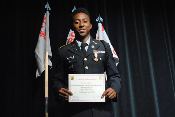 student on stage holding a certificate